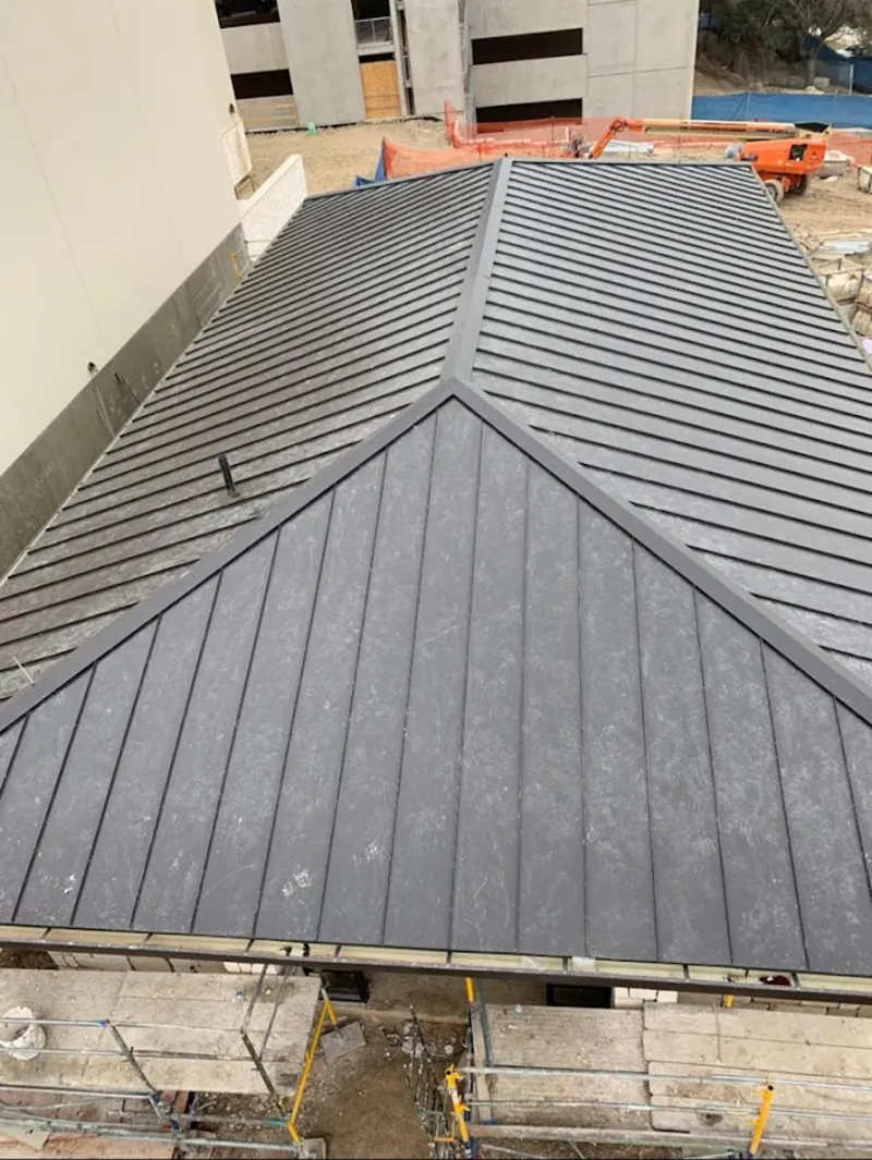 Commercial metal roof construction with crane equipment in Thornton